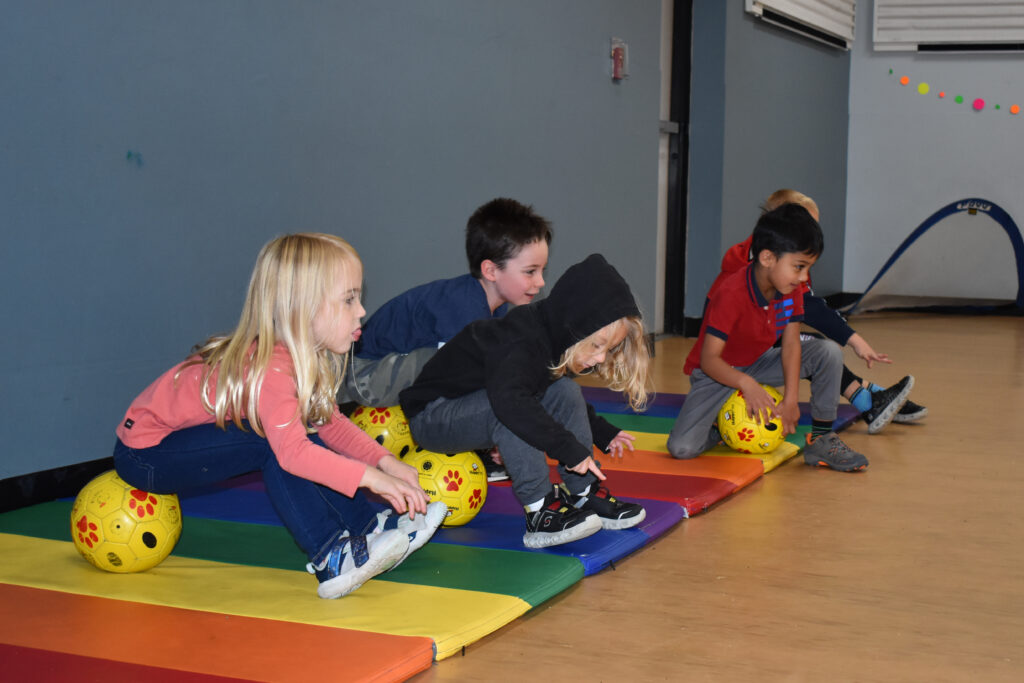 Children explore new ideas in a soccer class.
