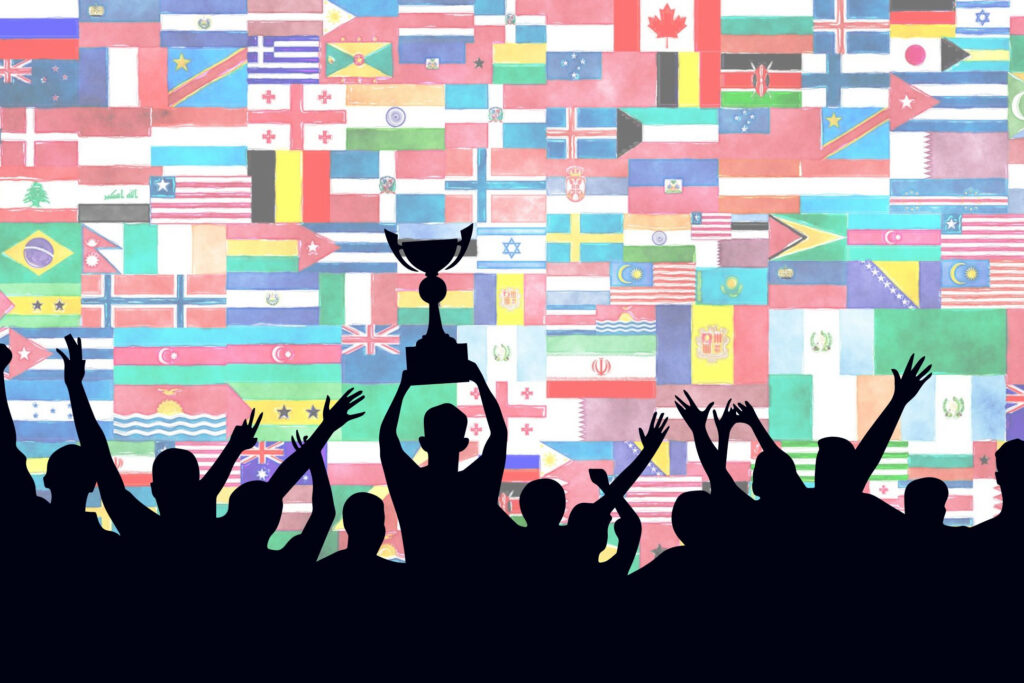 Flags of the world behind a crowd holding a trophy.