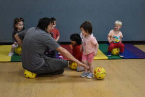 A coach helps a child with a new skill